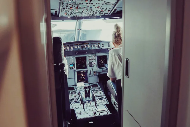 Deux pilotes en uniforme devant un avion de ligne, en route vers la porte d'embarquement
