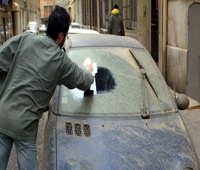 Voiture couverte de sable et de poussière saharienne déposée par le Sirocco dans une ville du bassin méditerranéen